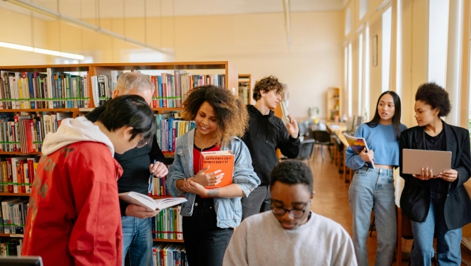 Dažādu tautību cilvēki darbojas bibliotēkā