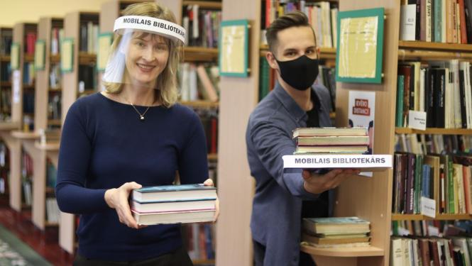 Bibliotekāri ar sejas aizsegiem kārto grāmatas 