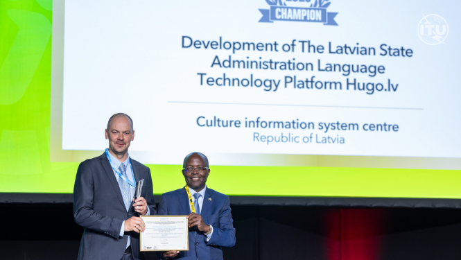 Jānis Ziediņš uz skatuves saņem platformai Hugo.lv piešķirto balvu