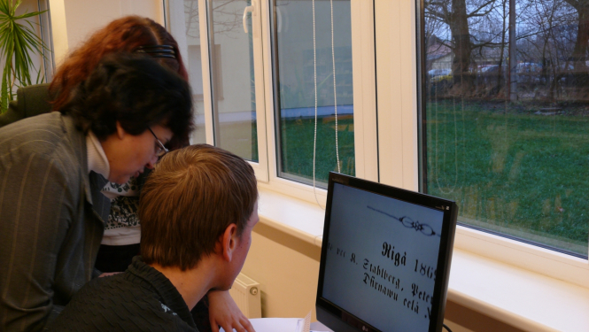 Bibliotēkas lietotāji strādā pie datora