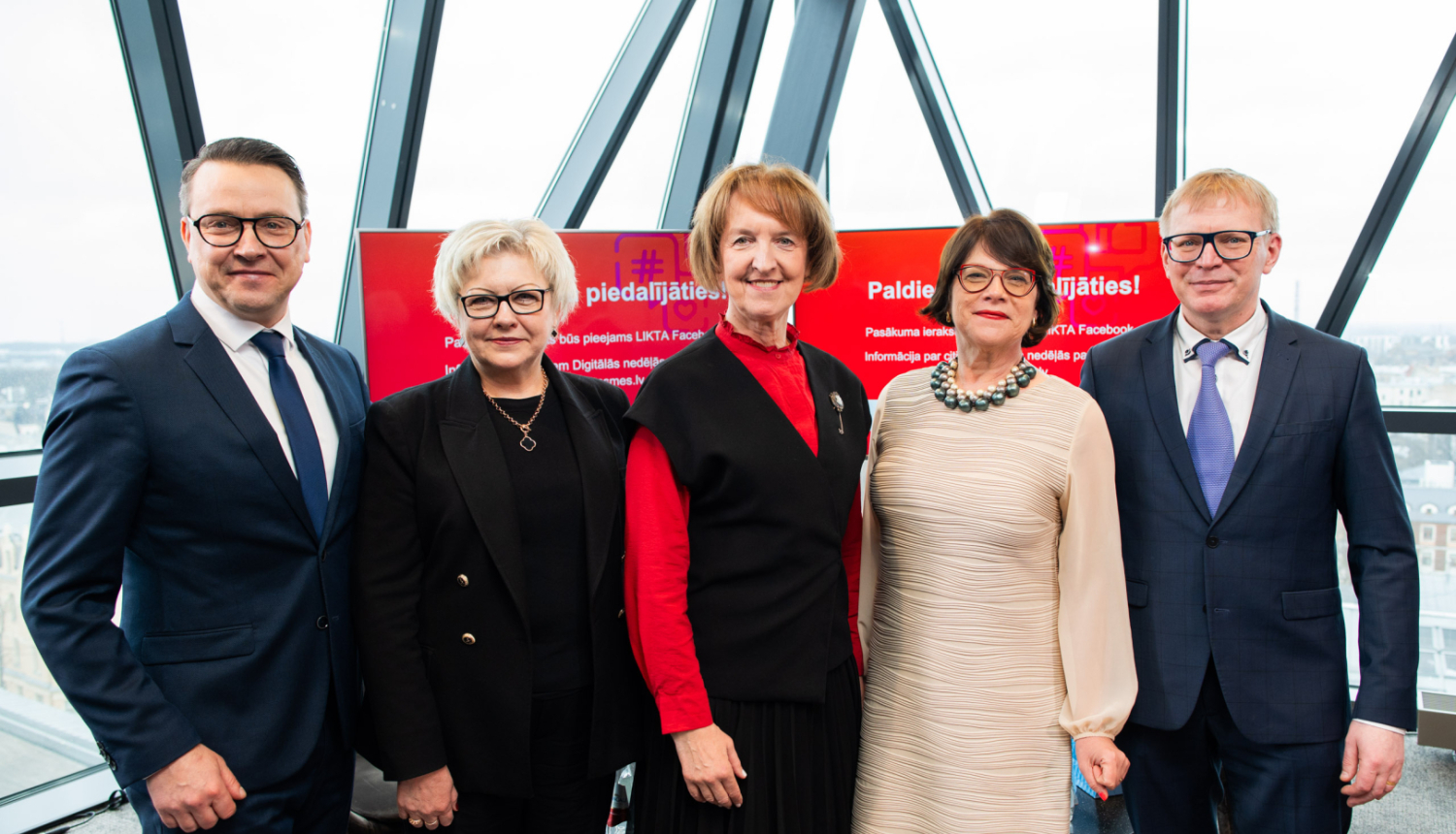 Diskusijas "Fokuss: prasmes digitālajā desmitgadē" dalībnieki ar Digitālās nedēļas baneri fonā