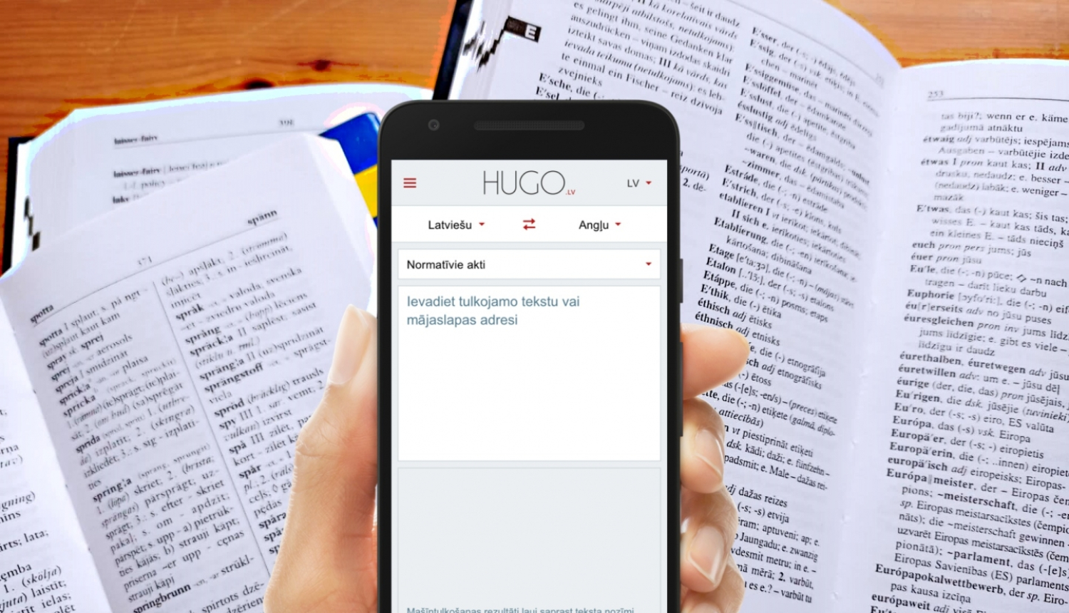 Viedtālrunis ar Hugo.lv lietotni uz atvērtu vārdnīcu fona